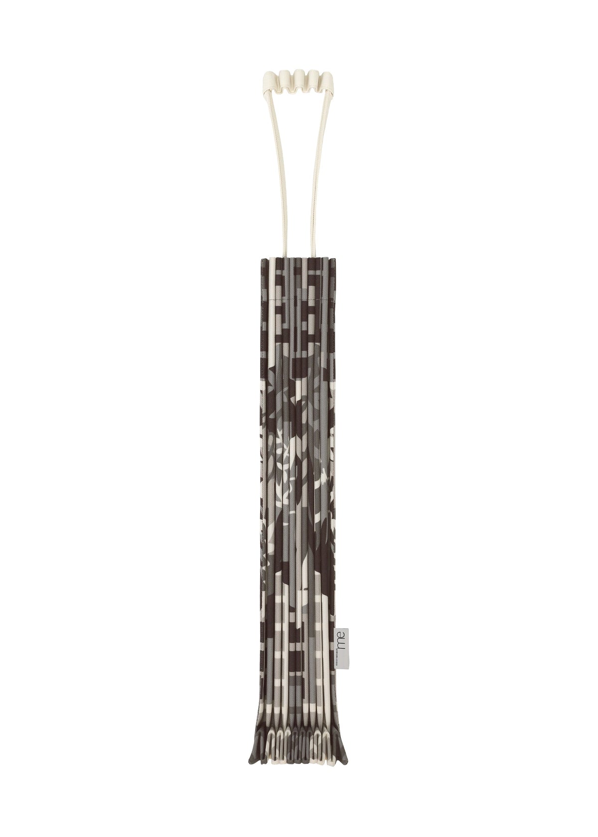 A vertically standing BUILDING TRUNK PLEATS BAG by me ISSEY MIYAKE, featuring a distinctive brown and beige patterned design, neatly wrapped in its matching cover with the same printed motif, set against a white background. view 1 of 8