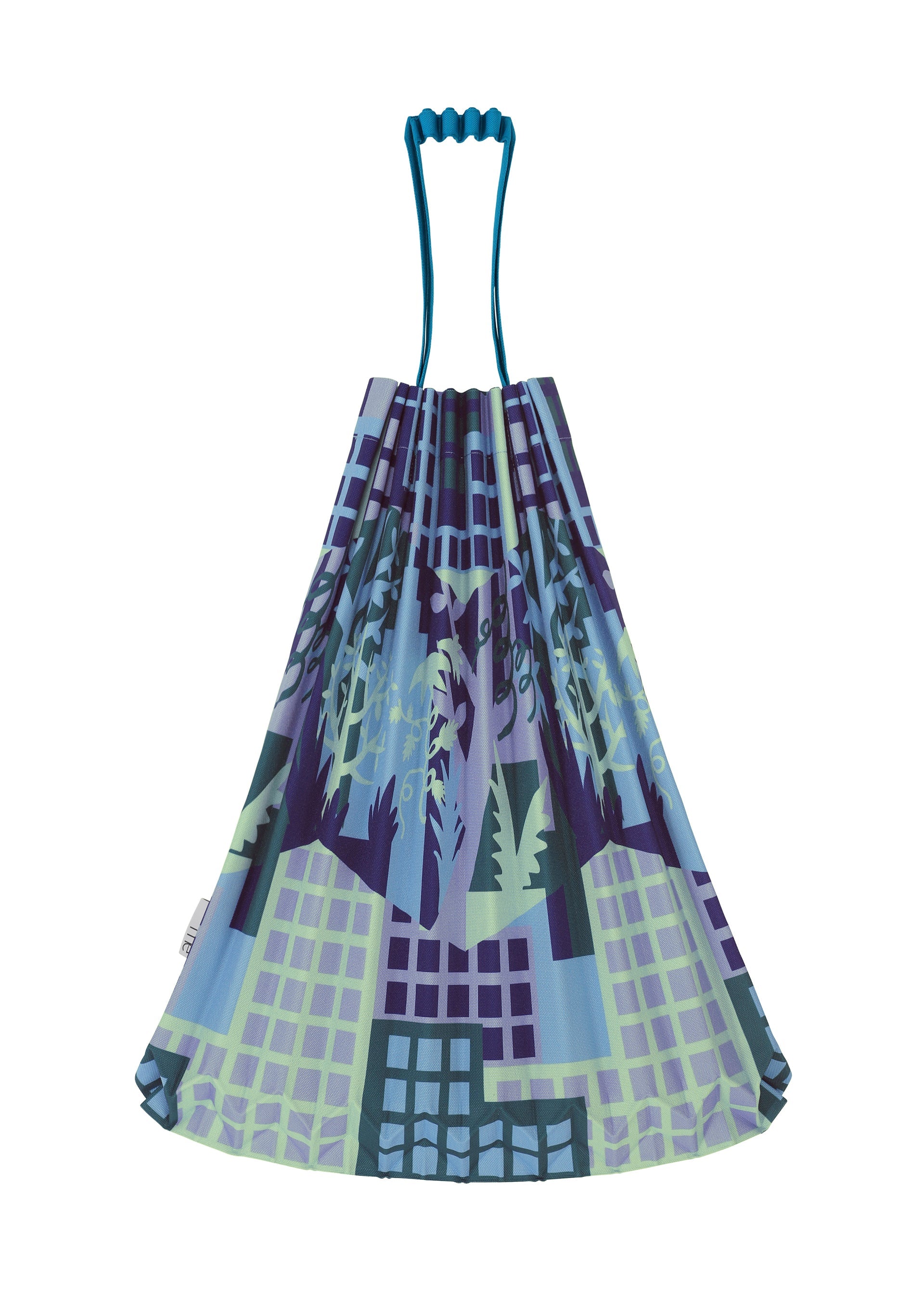 Zoomed view The BUILDING TRUNK PLEATS BAG by me ISSEY MIYAKE is a reusable tote featuring blue handles and an artistic cityscape pattern in shades of blue, purple, and green, with buildings, trees, and subtle urban farming elements.