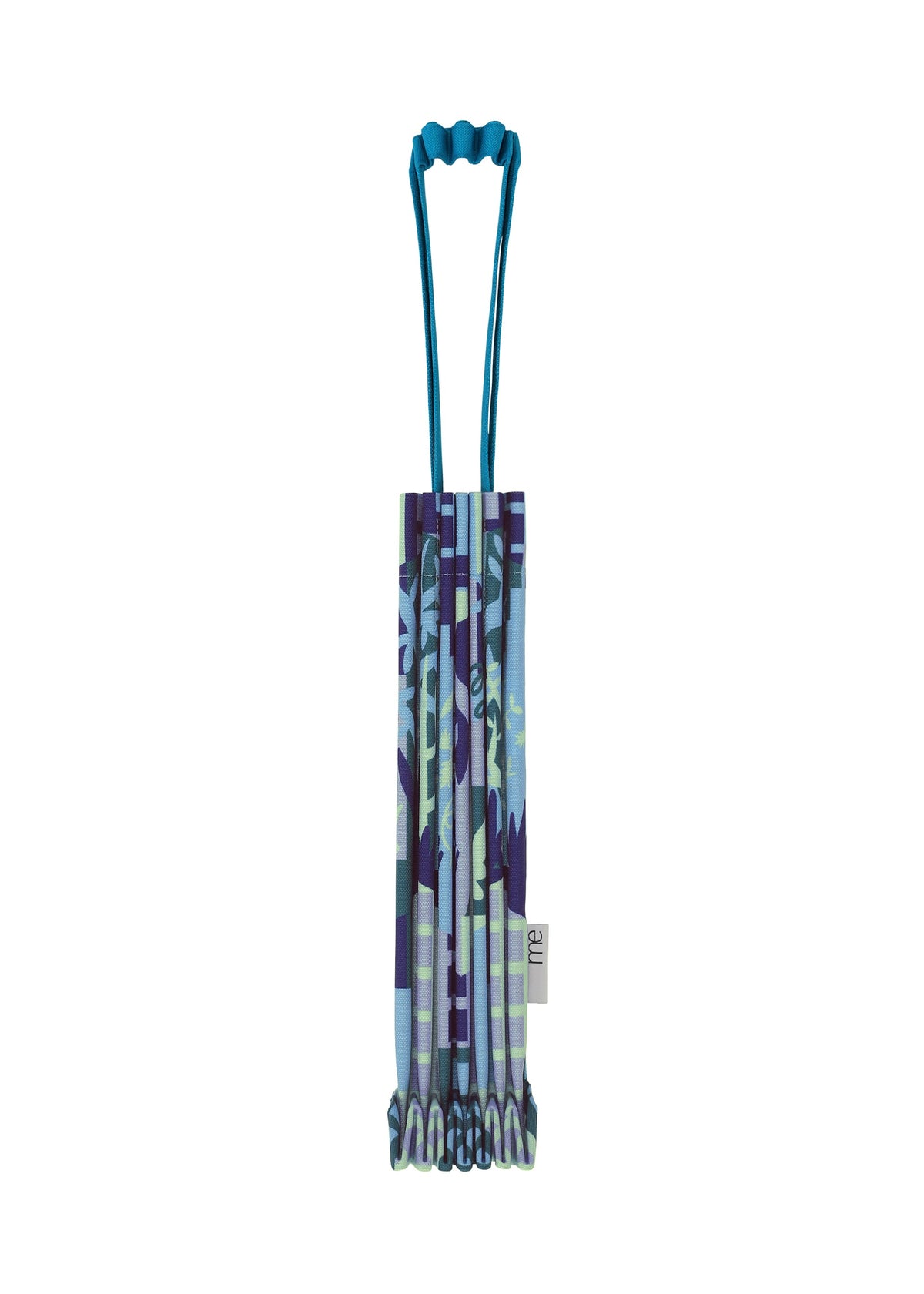 A folded, patterned BUILDING TRUNK PLEATS BAG by me ISSEY MIYAKE, featuring a unique handle and a multicolored blue, purple, and green camouflage-inspired design—perfect for urban adventures—stands upright on a white background. view 3 of 8