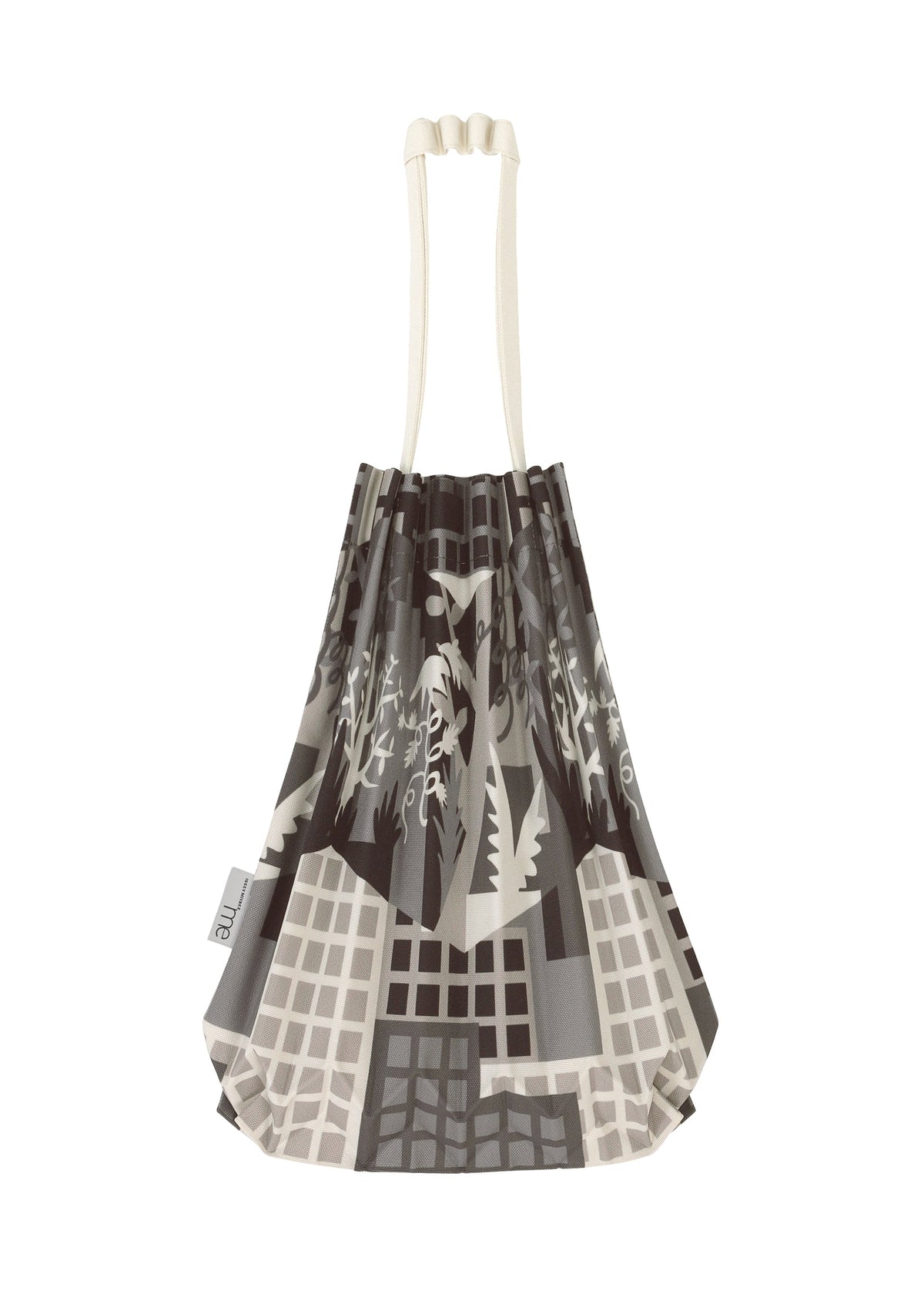 The BUILDING TRUNK PLEATS BAG by me ISSEY MIYAKE is a pleated mini tote featuring cream handles and an abstract grayscale cityscape design. The distinctive handle enhances its sophistication, while a small white tag accents one side. view 4 of 8