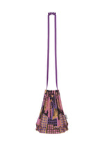 The BUILDING TRUNK PLEATS BAG by me ISSEY MIYAKE is a small shoulder bag featuring a long purple strap and a vibrant geometric pattern in shades of purple, pink, black, and gold.