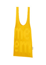 A yellow LOGO PLEATS BAG by me ISSEY MIYAKE with wide handles, textured ridges, subtle raised MEME branding on the front, and a small white tag on the right side. Crafted with a pleating machine.