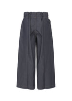 The FLAT DENIM pants by me ISSEY MIYAKE feature a wide-leg, high-waisted design in dark recycled polyester denim with an elastic waistband and visible center seams, shown from the back on a plain white background.