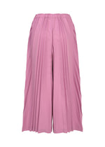 The TOWER PLEATS BOTTOM by me ISSEY MIYAKE is a pair of wide-leg pink culotte pants with handmade pleating and an elastic waistband, shown on a white background.