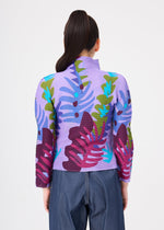 A person with long dark hair in a ponytail is shown from the back against a plain white background, wearing the me ISSEY MIYAKE JUNGLE high-neck, long-sleeve top featuring colorful abstract leaf patterns and wide-leg blue jeans.