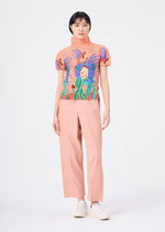 Against a white background, a person wears light pink wide-leg pants, white shoes, and the ISLAND high-neck stretchy top from me ISSEY MIYAKE, featuring an abstract pattern with people, plants, waves, and playful Philippines tarsiers.