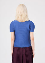A person with wavy, light blonde hair is shown from the back, wearing a blue short-sleeved round-neck top paired with the me ISSEY MIYAKE STRETCH PLEATS 2 skirt in deep burgundy, featuring subtle stretch pleats, set against a plain light background.