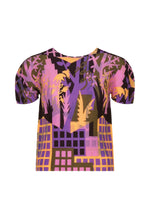 Introducing BUILDING by me ISSEY MIYAKE: a short-sleeved, pleated round-neck top adorned with a vibrant abstract print in purple, pink, yellow, and black tones—evoking imagery of buildings and foliage. This urban farming-inspired piece blends an eye-catching design with stretch pleats for effortless comfort and style. - PINK-HUED （no.27）