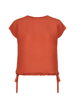 SQUARE STRETCH PLEATS short-sleeve ribbed round-neck top in rust orange by me ISSEY MIYAKE, featuring side ties at the hem for an adjustable silhouette, displayed on a white background.
