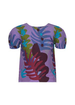 The JUNGLE top by me ISSEY MIYAKE is a short-sleeved piece featuring a purple base with an abstract jungle leaf pattern in red, green, blue, and teal on the front and sleeves, shown against a white background. - PURPLE-HUED （no.87）