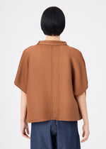 A person with short black hair stands with their back to the camera against a plain white background, wearing the me ISSEY MIYAKE SQUARE STRETCH PLEATS relaxed-fit brown short-sleeved cardigan paired with blue jeans.