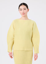 A person with dark hair in a low bun wears the light yellow CORDUROY PLEATS set by me ISSEY MIYAKE, featuring a pleated skirt and matching long-sleeved top, standing against a plain white background.