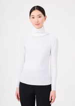 A woman with straight dark hair tied back is wearing the me ISSEY MIYAKE KNIT STRETCH PLEATS white turtleneck sweater and black pants, standing against a plain white background, facing forward and smiling softly.