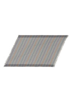 The STRIPE PLEATS STOLE by me ISSEY MIYAKE is a rectangular, fringed stole made from colorful yarn-dyed material, showcasing diagonal blue, orange, and purple stripes against a neutral background, displayed on a white surface. - GRAY-HUED （no.17）