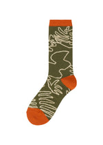 JUNGLE SOCKS by me ISSEY MIYAKE is a single olive green sock inspired by jungle socks, showcasing abstract white line designs reminiscent of plant pattern socks and finished with solid orange toe, heel, and cuff. Displayed on a plain white background. - BROWN-HUED （no.49）