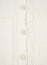 Close-up of a white, textured me ISSEY MIYAKE CAULIFLOWER JACKET with three round buttons down the center.