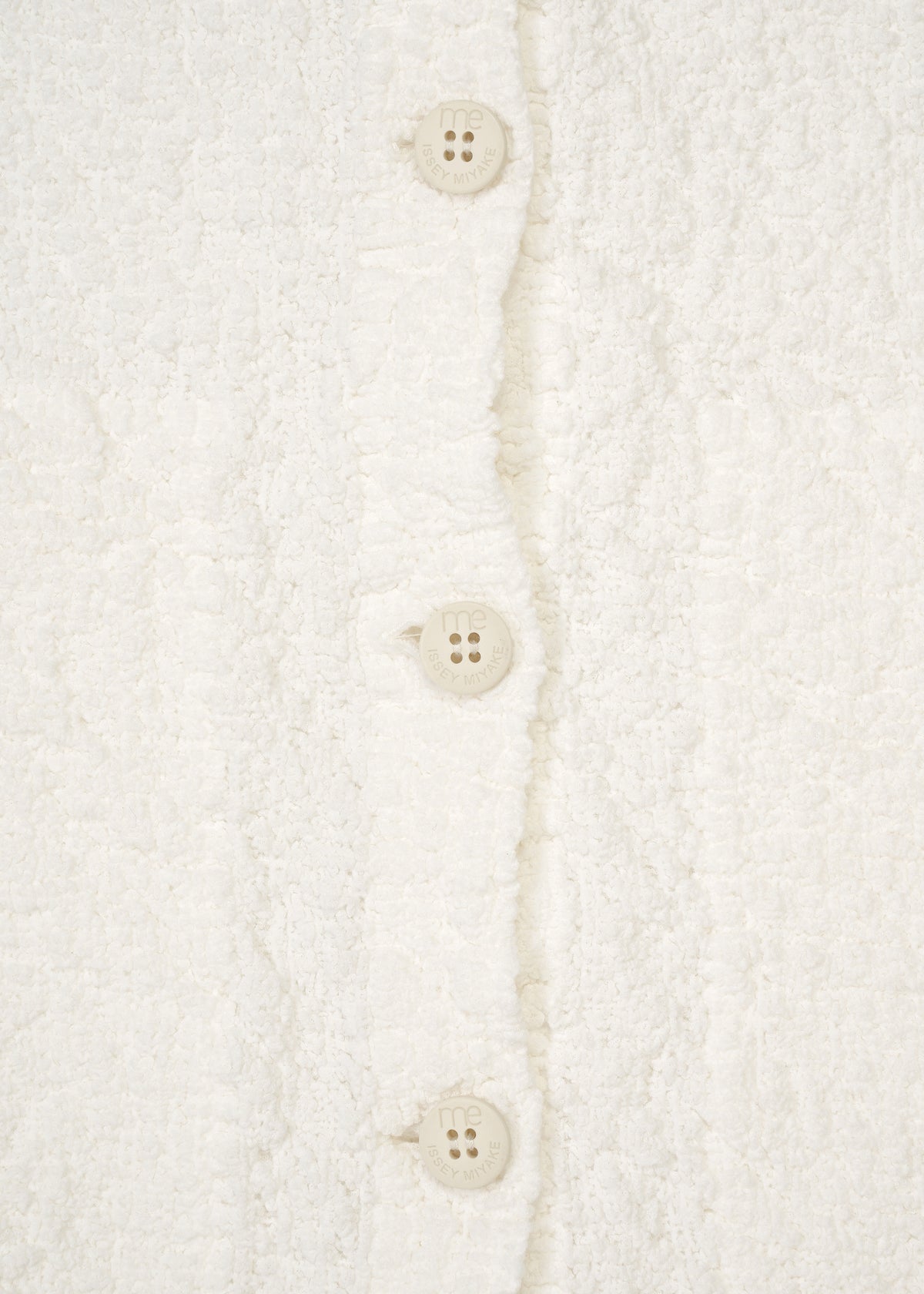 Zoomed view Close-up of a white, textured me ISSEY MIYAKE CAULIFLOWER JACKET with three round buttons down the center.
