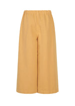 PINA CLOTH wide-leg, cropped pants in light brown by me ISSEY MIYAKE, featuring an elastic waistband and effortlessly styled with a garment-dyed jacket, displayed against a plain white background.