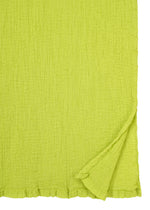 SEE-THROUGH CREPE COLOR by me ISSEY MIYAKE: a textured, bright yellow-green, product-dyed fabric with a crinkled finish, shown flat with the bottom right corner folded to reveal the underside of its high-twist threads.