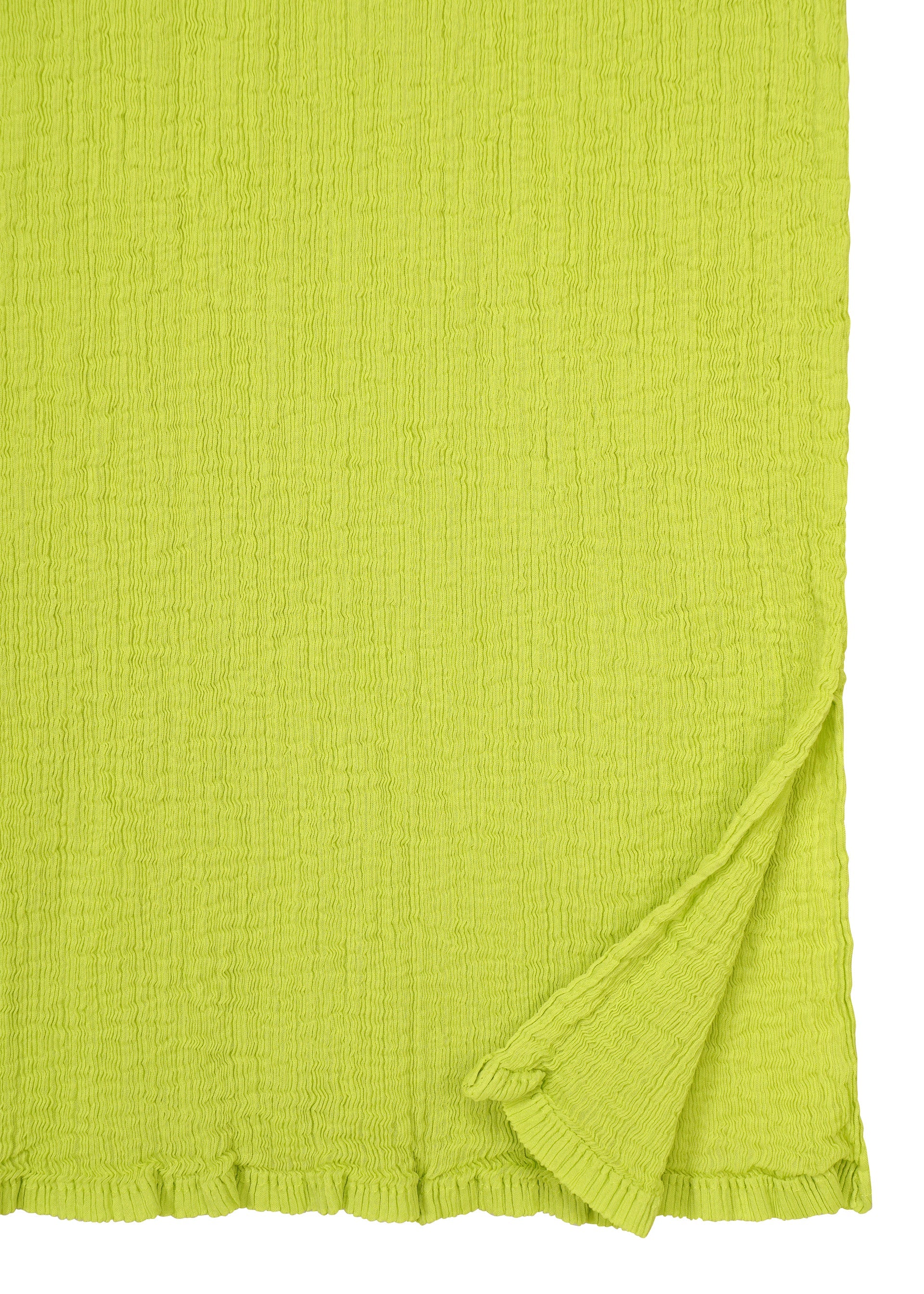 Zoomed view SEE-THROUGH CREPE COLOR by me ISSEY MIYAKE: a textured, bright yellow-green, product-dyed fabric with a crinkled finish, shown flat with the bottom right corner folded to reveal the underside of its high-twist threads.