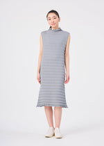 A young East Asian woman stands facing forward, dressed in the ACCORDION SEE-THROUGH CREPE midi dress from me ISSEY MIYAKE—a sleeveless, light gray piece featuring garment-dyed fabric, delicate accordion hand pleating, and a high neckline. She pairs the dress with matching slip-on shoes against a plain light gray background.