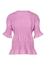 The SHRINK STRIPE blouse by me ISSEY MIYAKE features short ruffled sleeves, a round neckline, and smocked detailing across the bodice for added charm. Crafted from a lightweight, slightly crinkled cotton-blend fabric in light pink, this loose and flowy top is perfect for effortless style.