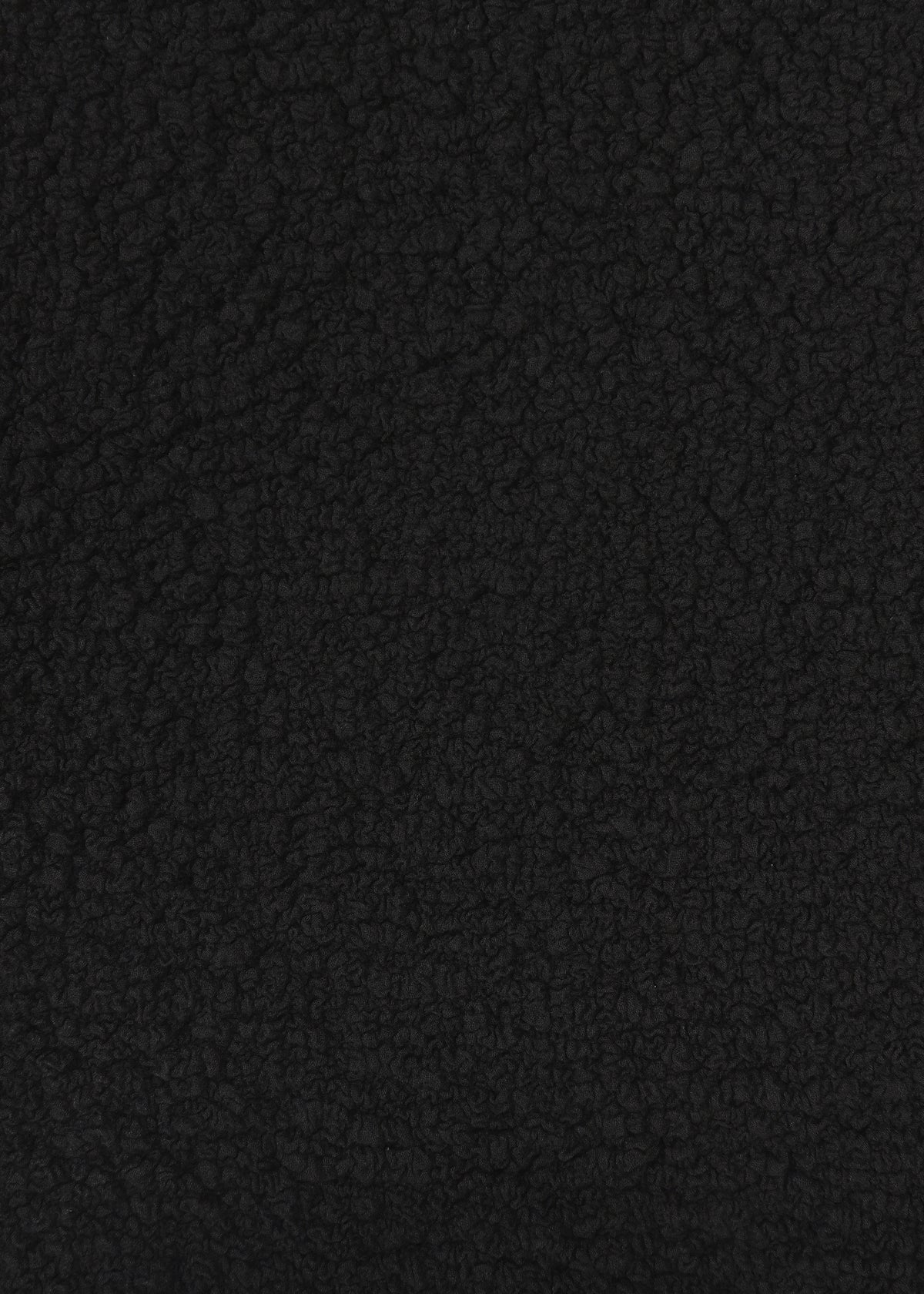 Close-up of CAULIFLOWER by me ISSEY MIYAKE—a textured, black material with a soft, bumpy surface reminiscent of fleece or sherpa—highlighting its cozy appeal in a cotton round-neck top. view 6 of 7
