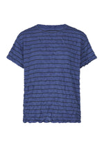 The STRIPE MERINGUE T-SHIRT by me ISSEY MIYAKE is a blue short-sleeve top made from soft polyester jersey, featuring a round neckline, textured crinkled fabric, and a horizontal stripe pattern. Displayed against a white background, this stylish shirt boasts a unique crushed finish. - BLUE-HUED （no.78）