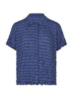 The STRIPE MERINGUE T-SHIRT by me ISSEY MIYAKE is a short-sleeved, blue button-up shirt featuring a collar and a crinkled horizontal striped pattern, displayed against a white background. - BLUE-HUED （no.78）