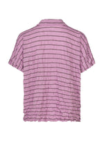 The STRIPE MERINGUE T-SHIRT by me ISSEY MIYAKE is a light purple, short-sleeved shirt featuring dark horizontal stripes and a distinctive crushed, crinkled texture. It offers a relaxed fit and is finished with a simple collar.