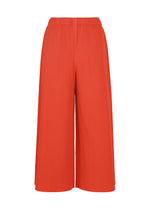 FINE KNIT PLEATS COLOR 2 wide-leg pleated culotte pants by me ISSEY MIYAKE, featuring a vibrant orange knit fabric and an elastic waistband, are displayed on a plain white background. - RED （no.24）