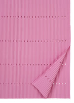 A pink, ribbed FINE KNIT PLEATS BOTTOM 1 from me ISSEY MIYAKE, featuring evenly spaced horizontal rows of small holes and a delicately folded corner that reveals the reverse side—its subtle structure and fine texture evoke the look of an elegant pleated knit skirt.