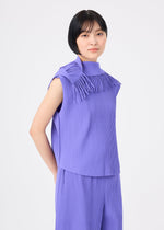 A person with short black hair wears the LEAF PLEATS set by me ISSEY MIYAKE—lightweight, textured lavender top with fringe details and matching pants—while standing against a plain white background.