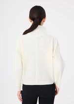 A woman with dark hair in a low ponytail is shown from the back, wearing the FINE KNIT PLEATS long-sleeve turtleneck top by me ISSEY MIYAKE with black pants, against a plain white background.