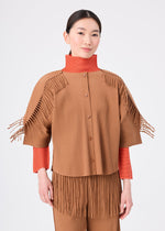 A person wearing the LEAF PLEATS outfit by me ISSEY MIYAKE—brown, pleated, and fringed—layered over a fine knit orange long-sleeved cardigan stands against a plain white background, looking at the camera with a neutral expression.