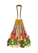 The TRUNK PLEATS BAG / NY by me ISSEY MIYAKE is a pleated mini tote with brown handles, an orange, green, pink, and white floral pattern, and a small side tag inspired by Madison Square Park.