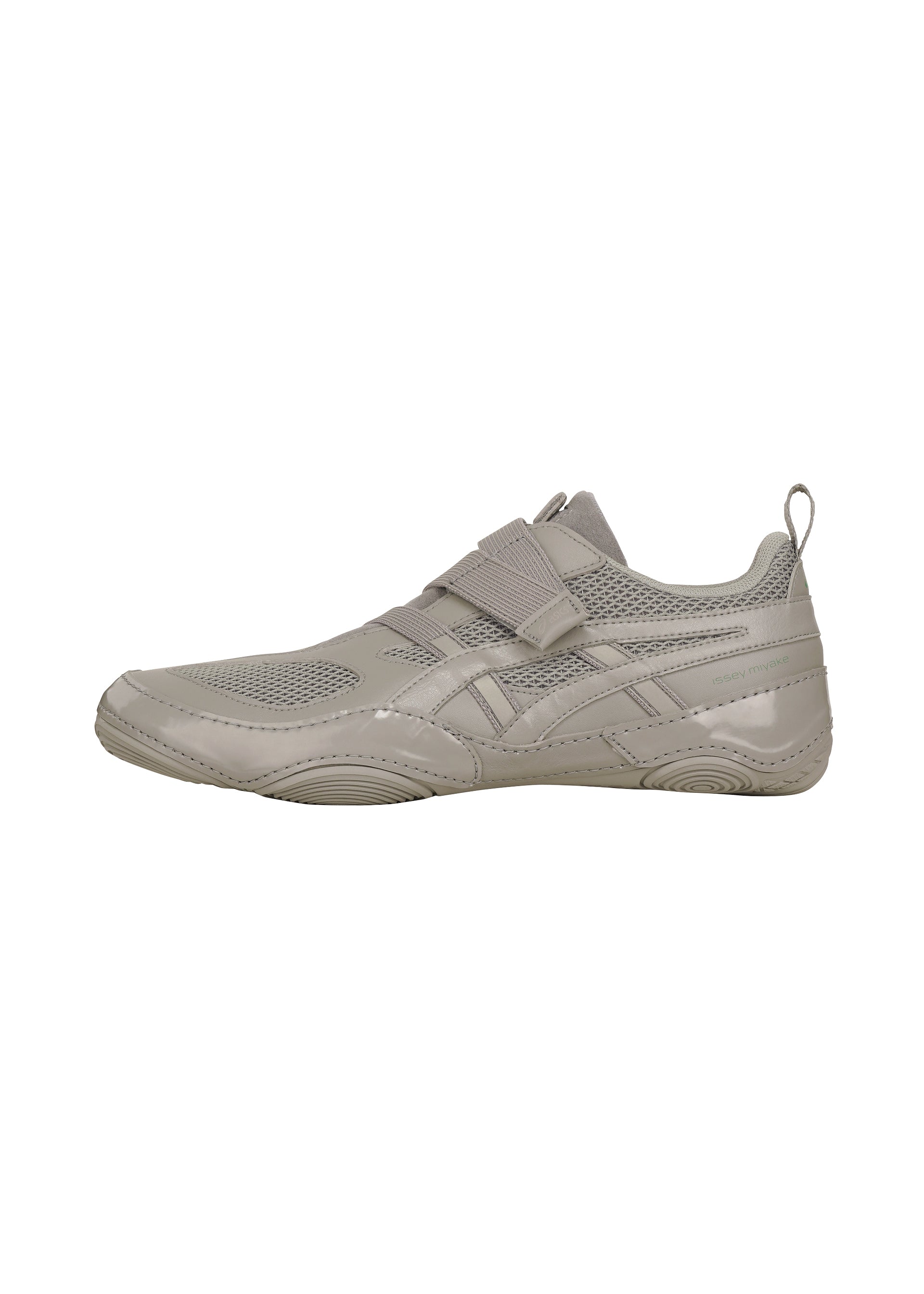 Zoomed view The ISSEY MIYAKE FOOT HYPER TAPING sneaker, in light gray mesh with synthetic overlays, a Velcro strap inspired by athletic taping, and a heel pull tab, is shown in side profile on a white background.