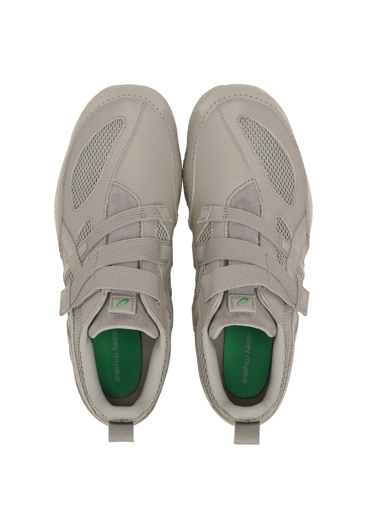 A pair of light gray ISSEY MIYAKE FOOT HYPER TAPING sneakers with mesh and leather details, green insoles and laces, viewed from above on a white background. view 5 of 6