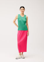 A woman wears a green round-neck sleeveless top from the NEW COLORFUL BASICS 5 collection by PLEATS PLEASE ISSEY MIYAKE, paired with a pink pleated midi skirt and white sneakers.