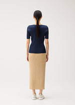 A model from behind wearing a NEW COLORFUL BASICS 5 short-sleeved, round-neck navy pleated top and a long tan pleated skirt with white sneakers.