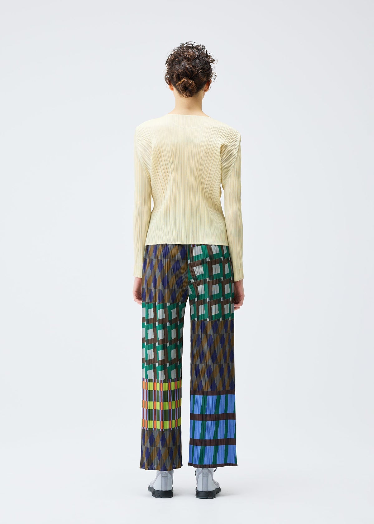 A person faces away, wearing the HARMONY long-sleeve ribbed top and wide-leg geometric print pants by PLEATS PLEASE ISSEY MIYAKE, against a plain white background. view 6 of 6