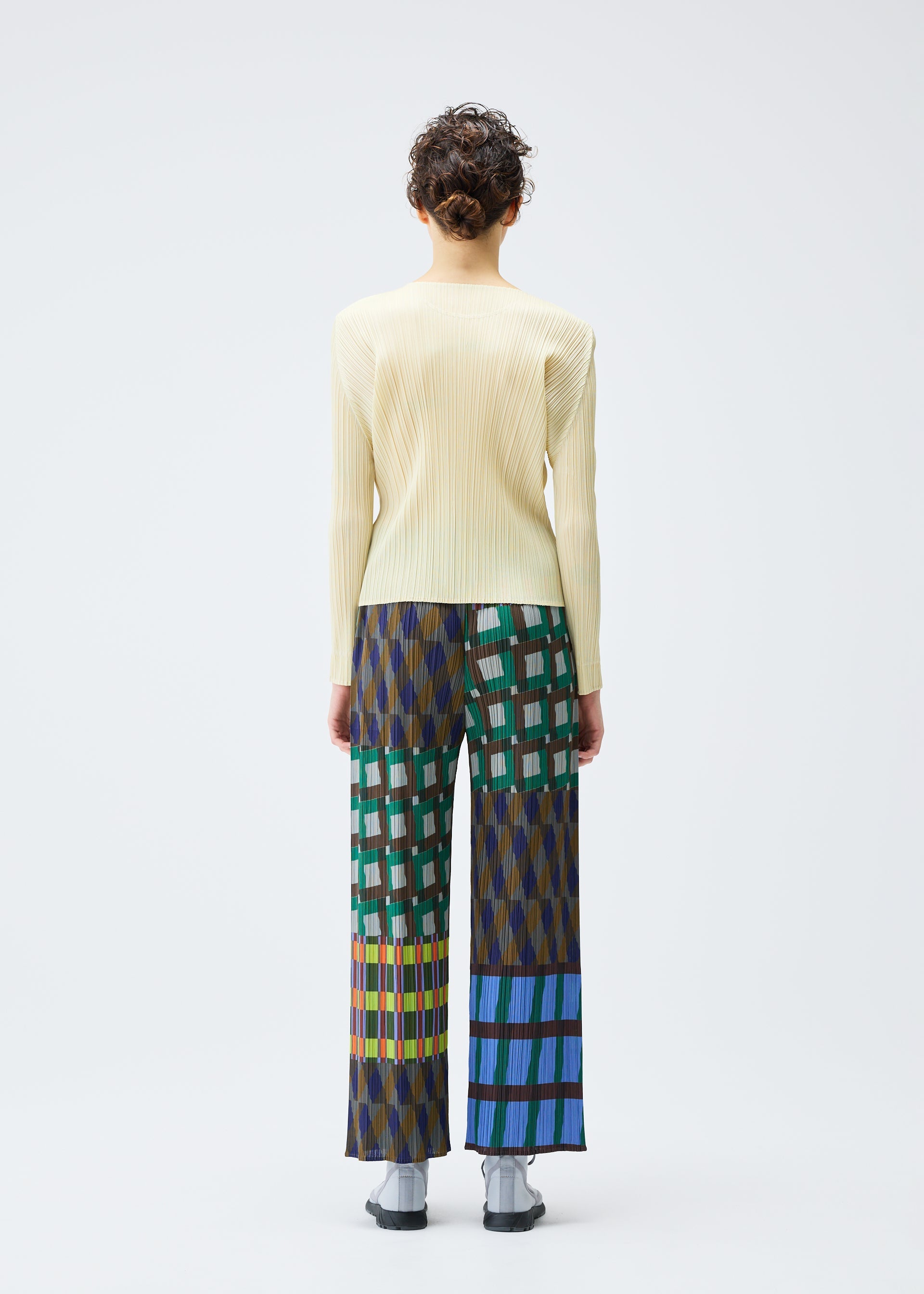Zoomed view A person faces away, wearing the HARMONY long-sleeve ribbed top and wide-leg geometric print pants by PLEATS PLEASE ISSEY MIYAKE, against a plain white background.