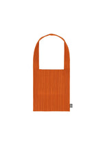 The CREPE KNIT BAG by PLEATS PLEASE ISSEY MIYAKE is a rectangular orange pleated tote with a wide strap and a small black-and-white tag on the lower right, featuring subtle horizontal knitting, shown against a plain white background. - DARK ORANGE （no.33）