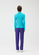 A person with short brown hair stands facing away, wearing the RIB PLEATS JANUARY set by PLEATS PLEASE ISSEY MIYAKE—a bright blue high-neck ribbed top and purple ribbed pants—paired with white shoes, against a plain white background.