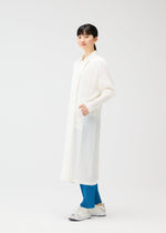 A young woman wears a collared long coat with a straight silhouette over bright blue pants and white sneakers, on a plain light background—an effortless look from PLEATS PLEASE ISSEY MIYAKE's MONTHLY COLORS : FEBRUARY series.