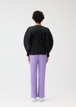 A person with short, curly hair stands with their back to the camera against a white background, wearing PLEATS PLEASE ISSEY MIYAKE's MONTHLY COLORS : APRIL—a black pleated oversized top with dolman sleeves and lilac pleated pants.