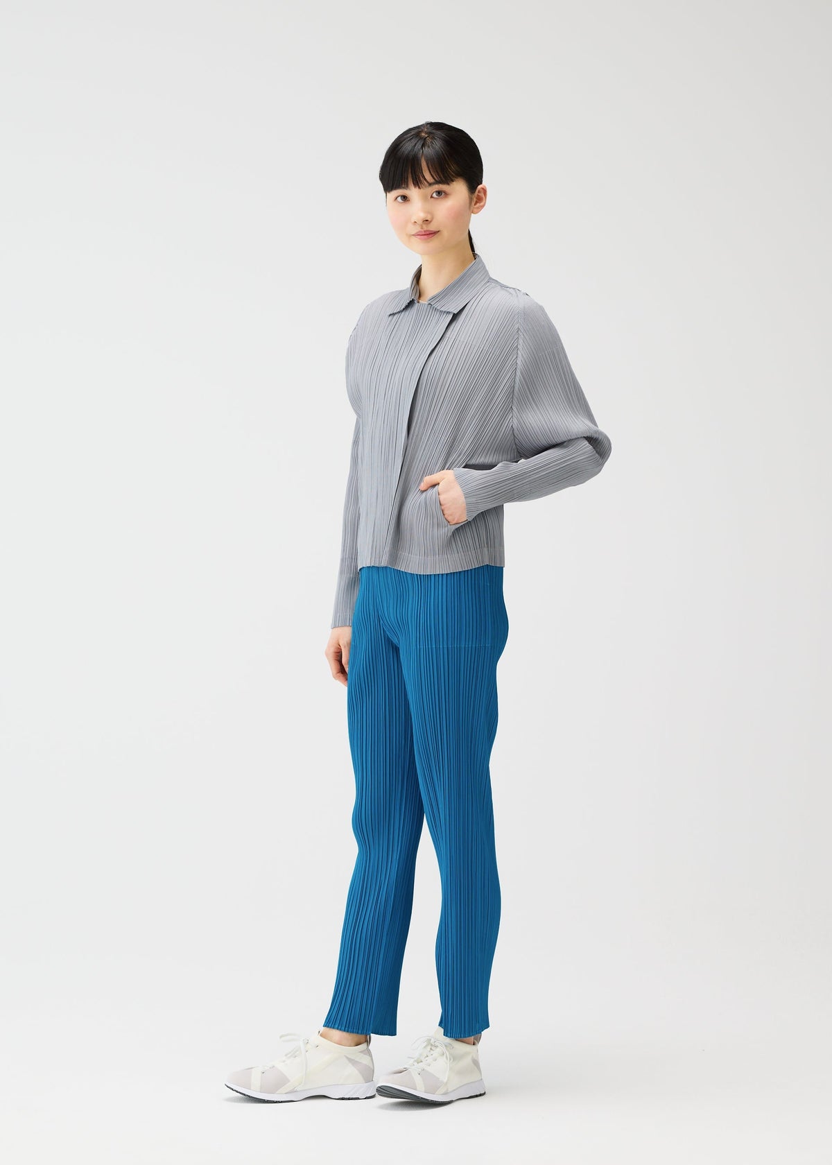 A woman with her hand in her pocket wears a collared jacket from PLEATS PLEASE ISSEY MIYAKE’s MONTHLY COLORS : FEBRUARY, reflecting the series’ relaxed yet polished style. view 11 of 11