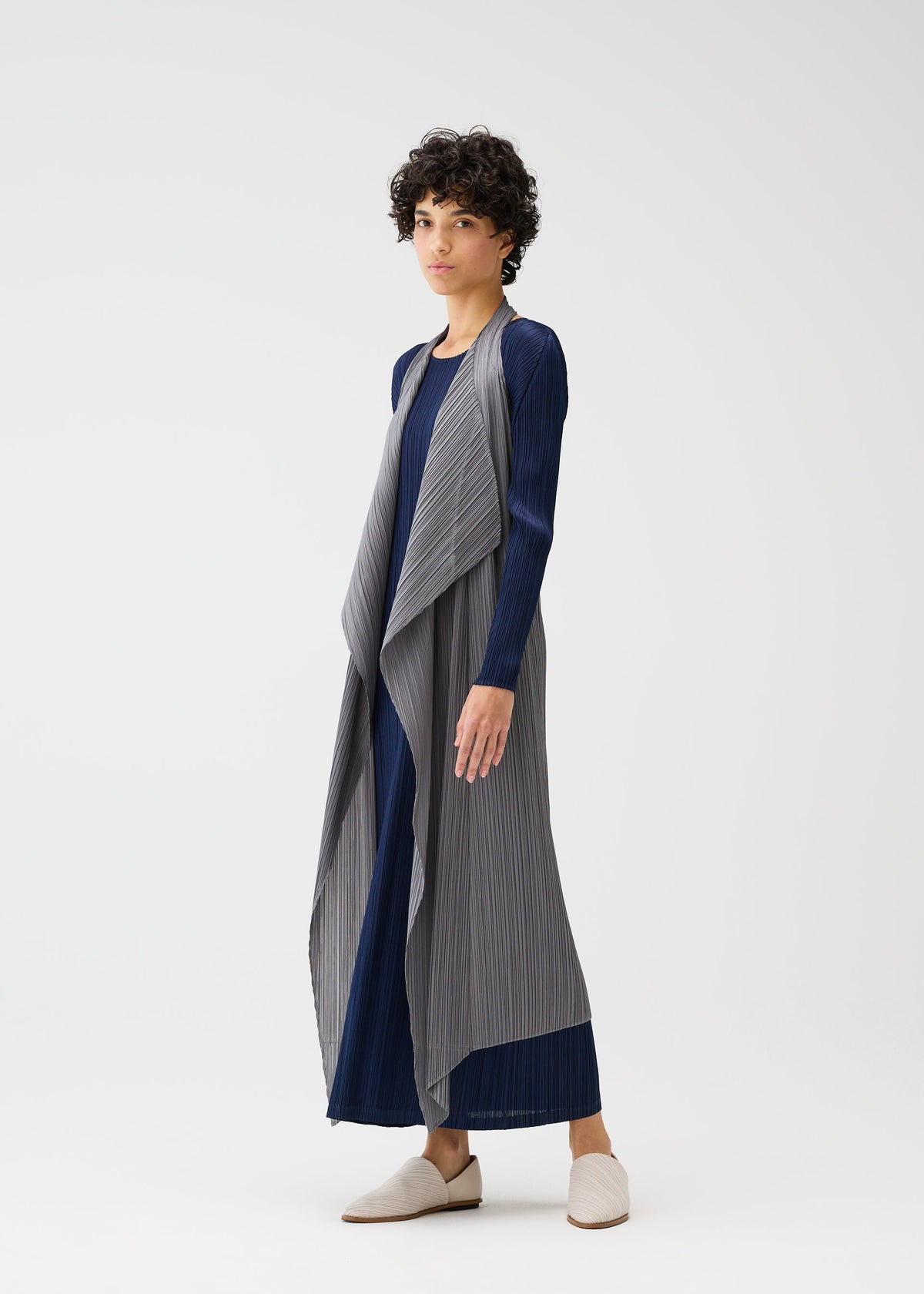 A woman wearing the MONTHLY COLORS : JANUARY dress and pleated vest by PLEATS PLEASE ISSEY MIYAKE. view 11 of 11
