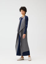 A woman wearing the MONTHLY COLORS : JANUARY dress and pleated vest by PLEATS PLEASE ISSEY MIYAKE.