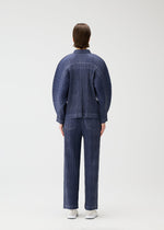A person faces away from the camera, wearing a blue COTTON DENIM pleated set with wide sleeves and matching pants by PLEATS PLEASE ISSEY MIYAKE, against a plain white background.